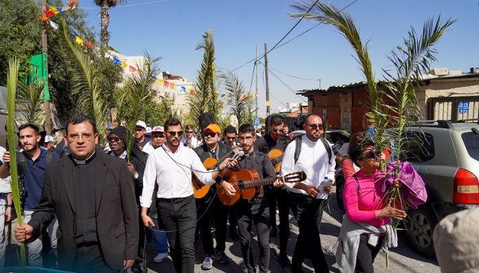 Curas con guitarras y peregrinos con palmas en Domingo de Ramos en Jerusalén 2023