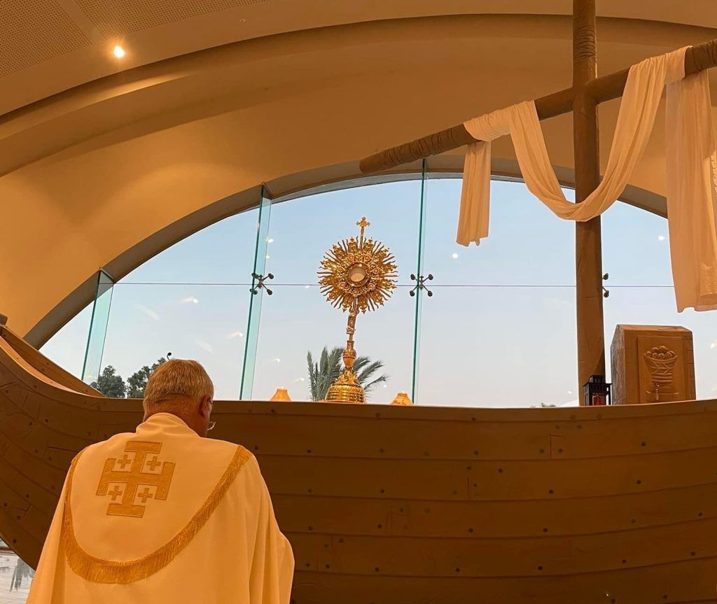 El P. Juan Solana en adoración en el altar de Magdala con forma de barca galilea