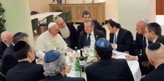 Un grupo de rabinos rodea al Papa Francisco en torno a la mesa.