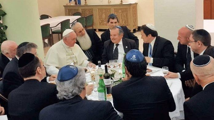 Un grupo de rabinos rodea al Papa Francisco en torno a la mesa.