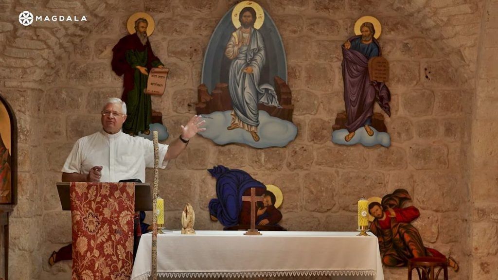 El padre Juan Solana, hablando desde el púlpito de un templo.