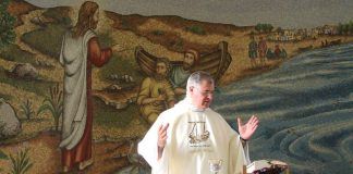 El padre Juan Solana celebra misa en Magdala, junto a una representación de Jesús predicando junto al Mar de Galilea.